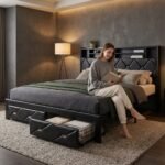 Woman relaxing on a sturdy black metal platform bed with a bookshelf headboard and convenient pull-out storage drawers in a contemporary bedroom. Custom and wholesale B2B furniture by MMK TRADE INC.