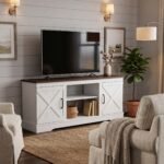 Modern white farmhouse TV stand with a rustic brown wood top and open center shelves in a cozy living room. Manufactured by MMK Furniture Makers for US wholesale and B2B furniture buyers.