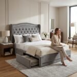 Woman relaxing on a custom grey velvet upholstered storage bed, high-quality B2B bedroom furniture by MMK Furniture Makers.