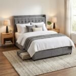 Modern grey velvet tufted bed frame with metal slats and under-bed storage drawers in a cozy bedroom setting, manufactured by MMK Furniture Makers for wholesale and B2B markets.