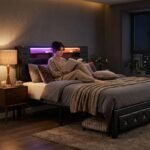 Person relaxing on a custom black upholstered bed frame with glowing LED headboard and storage, supplied by MMK TRADE INC.