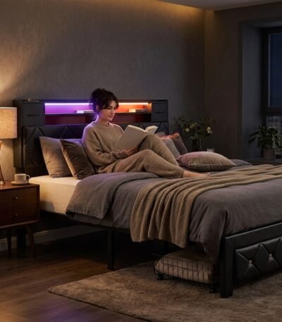 Person relaxing on a custom black upholstered bed frame with glowing LED headboard and storage, supplied by MMK TRADE INC.