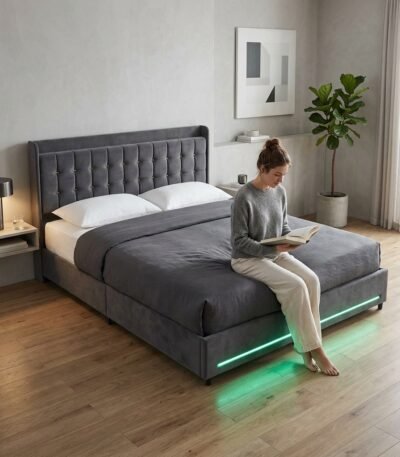 Woman sitting on a custom grey velvet LED bed frame, demonstrating premium B2B bedroom furniture quality by MMK Furniture Makers USA.