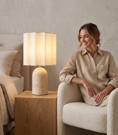 Custom OEM travertine stone desk lamp glowing beside a woman relaxing in a contemporary suite by MMK Furniture Makers