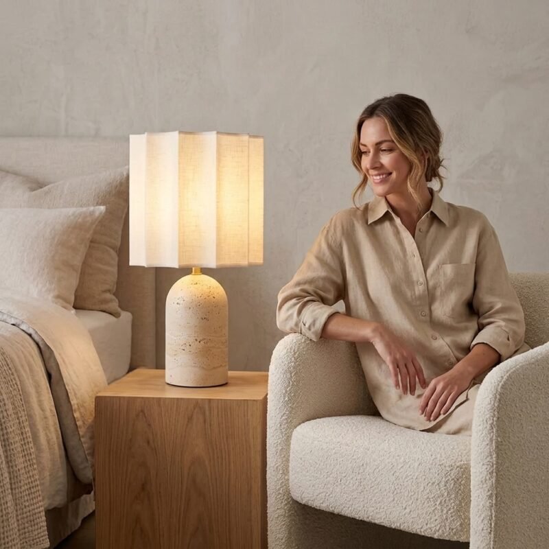 Custom OEM travertine stone desk lamp glowing beside a woman relaxing in a contemporary suite by MMK Furniture Makers