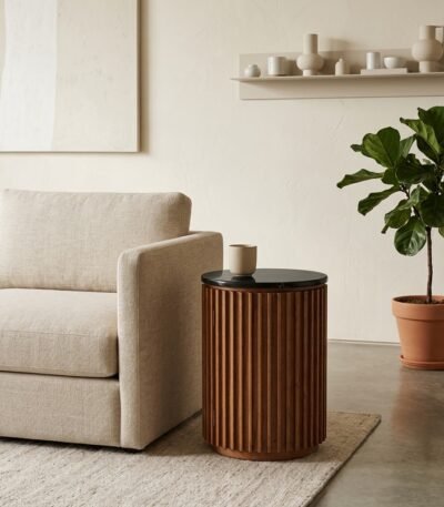 Custom-round-fluted-wood-accent-table-placed-next-to-a-modern-sofa.