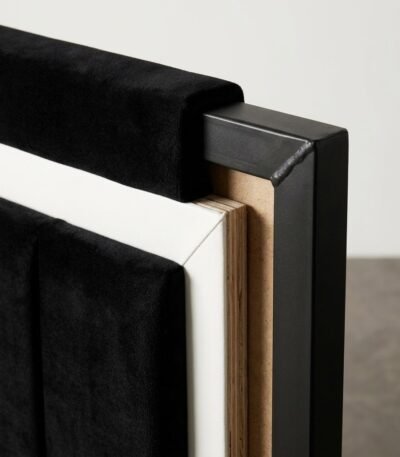 Detailed-corner-view-of-a-high-end-bedstead-showing-velvet-white-trim-and-metal.