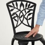 A-hand-rests-on-the-textured-seat-of-the-black-aluminum-chair.