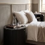 Black-round-fluted-nightstand-with-marble-top-in-modern-luxury-bedroom.