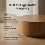 Low-angle-shot-highlighting-the-sturdy-drum-base-and-premium-finish-of-the-round-wooden-coffee-table.