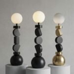 Three-variations-of-the-geometric-floor-lamp-side-by-side-standard-black-one-with-a-different-stacked-shape-arrangement-and-one-with-a-mixed-brushed-brass-and-black-finish.
