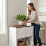 Woman-placing-home-decor-items-onto-a-white-MMK-farmhouse-buffet-storage-cabinet.