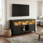 Matte black modern farmhouse TV stand with warm LED lighting and barn door storage by MMK Furniture Makers